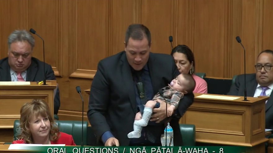 Labour MP Tamati Coffey cradles baby while speaking in Parliament